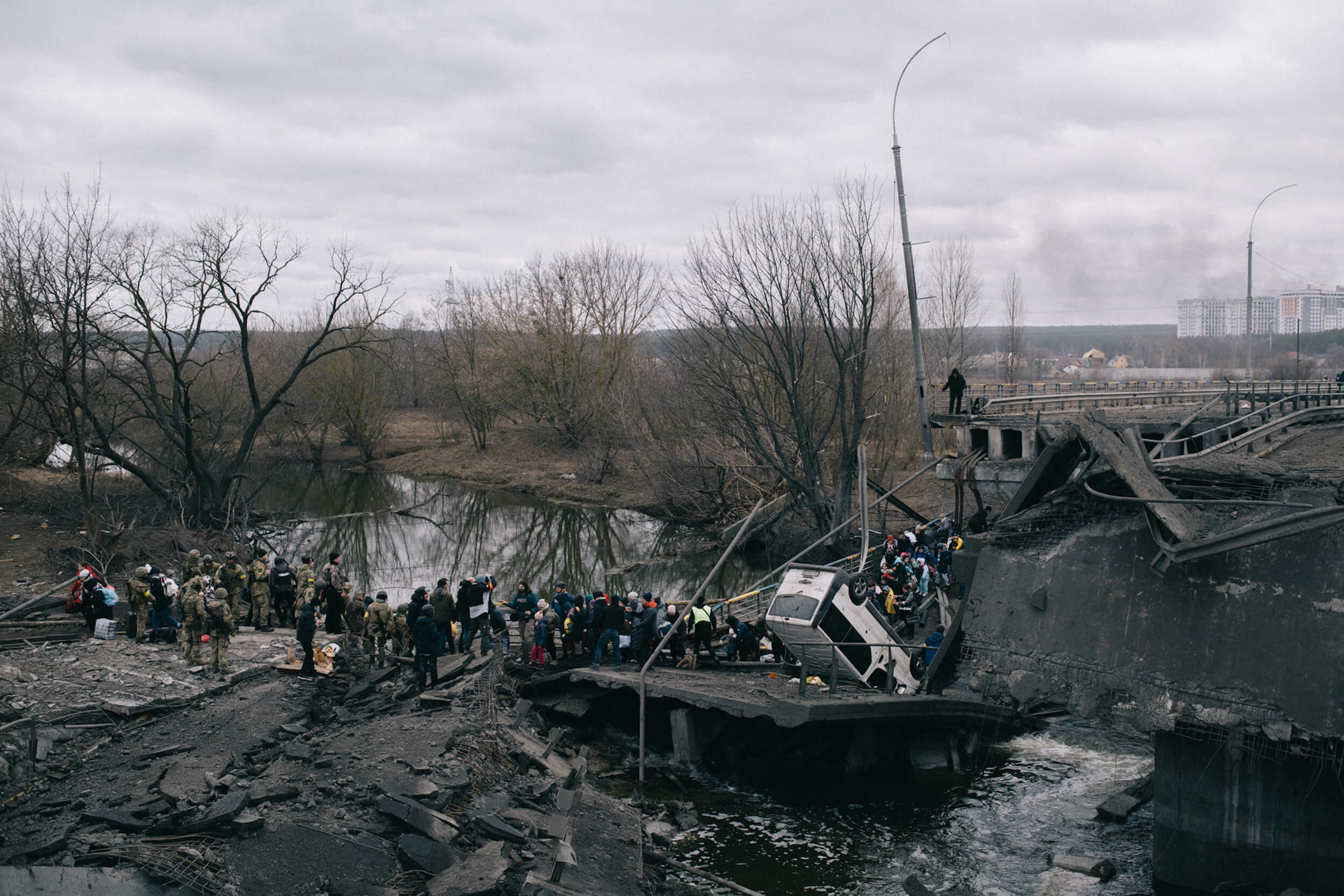 Evacuation of civilians from Irpin town, through a bridge destroyed by shelling. The bridge was destroyed by the Armed Forces of Ukraine to prevent the enemy from reaching Kyiv. On this day at 10 am women, children and the elderly were supposed to be evacuated from the town by trains, but the enemy blew up the railroad tracks, and so people were asked to move to another place, from where they should be picked up by buses for transportation to the Kyiv railway station. Irpin town, Kyiv region, Ukraine, 05 March, 2022 Евакуація населення з міста Ірпінь через зруйнований обстрілом міст. Збройні сили України знищили міст, щоб не допустити ворога до Києва. Того дня о 10:00 з міста мали евакуювати потягами жінок, дітей та старих. Але ворог підірвав залізничну колію, тому людей попросили переїхати в інше місце, звідки їх мали забрати автобуси для перевезення до Київського вокзалу. Ірпінь, 5 березня